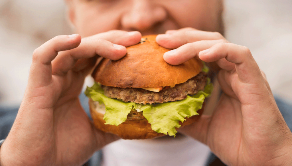 Dicker Mann ist einen Burger